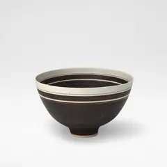 Lucie Rie, Footed bowl, circa 1965, Porcelain, alternating manganese and unglazed banding with single thin inlaid band near rim
