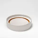 Edmund de Waal, Low cylinder with floating base, circa 2002, Porcelain, shiny white glaze, the centre of well with floating base and a shiny deep ochre glaze to the interior well