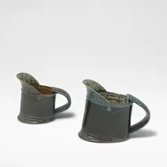 Walter Keeler, Two jugs, Stoneware, blue salt glazes with running olive green and brown salt glazes to interiors, each mounted with a strap handle
