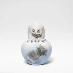 Royal Copenhagen, 'Owl on ball', model no. 1101, circa 1914, Porcelain, decorated in polychrome, the sphere decorated with motifs of pine shoots