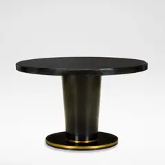 Jean Pascaud, Dining table, circa 1930, Ebonised wood, the circular top with a black glass insert, raised on a flaring column base, terminating onto a brass banded circular foot