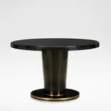 Jean Pascaud, Dining table, circa 1930, Ebonised wood, the circular top with a black glass insert, raised on a flaring column base, terminating onto a brass banded circular foot
