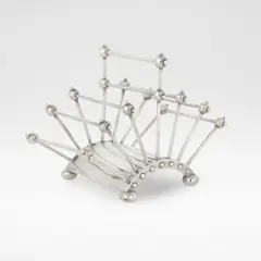 Christopher Dresser, Letter rack, model no. 2555, 1888, Sterling silver, the curved base with six adjustable divisions, raised on bun feet, centred by a carrying handle