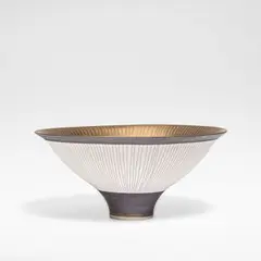 Conical footed bowl by Lucie Rie, circa 1980, Porcelain, golden bronze glaze to interior, the exterior unglazed with manganese banding, sold Dec 2025