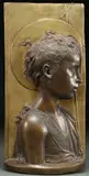 Desiderio da Settigano, The Young St. John the Baptist, Bronze relief plaque with dark brown and gilt patina