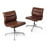 Pair of Soft Pad Chairs by Charles and Ray Eames, brown leather and aluminium, sold Oct 2021