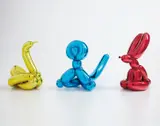 Jeff Koons, Balloon Swan (Yellow); Balloon Monkey (Blue); and Balloon Rabbit (Red), 2017, Three porcelain multiples painted in chrome, all contained in the original foam lined boxes with silver printed signature