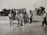 Carl Mydans, Gen. Douglas MacArthur with Gen. Richard Sutherland and Col. Lloyd Lehrbas walks through the surf to the beach at Lingayen, Luzon, the Philippines, 1945, Gelatin silver print