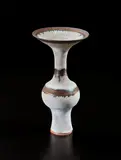 Bottle with flaring lip by Lucie Rie, 1976, Stoneware, inlaid shoulder and lip, with golden manganese bands and matte-white glaze, offered Jun 2018