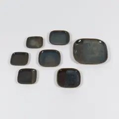 Pierre Culot, Suite de six assiettes et un grand plat, A set of six plates and one serving dish in partially glazed stoneware by Pierre Culot circa 1988 and circa 1985 with the artist's seals