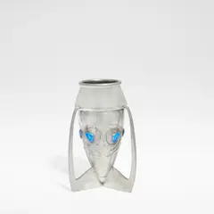 Archibald Knox, for Liberty & Co., circa 1902, Pewter, the bullet shaped body set with enamelled cabochons to the sides