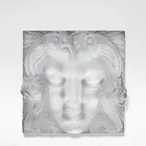 'Masque de Femme', plaque, originally designed 1935, this example manufactured post-1945 by René Lalique, Frosted and moulded glass, modelled in relief with a female face framed by fish, sold Sep 2025