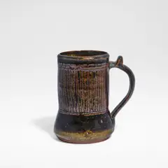 Ladi Kwali, Tankard, Glazed stoneware, tenmoku glaze with streaked iron decoration, the curved handle with a thumbpiece