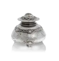 Inkwell by Omar Ramsden, 1920, Silver, the domed body set with flowerheads joined by braids, the hinged lid with a Tudor rose within a braided surround, offered Dec 2024
