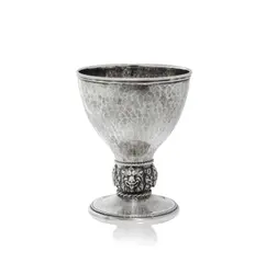 Chalice by Omar Ramsden, 1923, Silver, the hammered bowl raised on knop stem with lion masks in relief separated by rosettes, on a splayed foot, sold Dec 2024