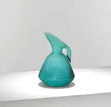 Christopher Dresser, for William Ault & Co., circa 1895, Glazed earthenware, of tapering form rising to a pinched spout, decorated in a graduated blue glaze with incised foliate motifs