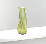 for James Couper & Sons by Christopher Dresser, circa 1895, Green glass, the twisted body tapering to a flat circular rim, sold Mar 2025