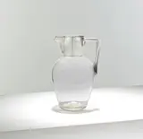 Claret jug by Christopher Dresser, 1903, Sterling silver handle and collar on an ovoid clear glass body, sold Mar 2025