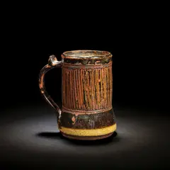 Ladi Kwali, Tankard, Glazed stoneware, tenmoku glaze with streaked iron decoration, the curved handle with a thumbpiece