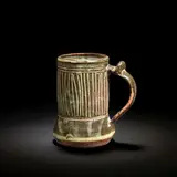 Ladi Kwali, Tankard, Glazed stoneware, tenmoku glaze with streaked iron decoration, the curved handle with a thumbpiece