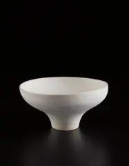 Footed bowl by Lucie Rie, circa 1978, Porcelain, matte white glaze over concentric inlaid blue lines repeated inside and out, sold Jun 2017