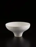 Footed bowl by Lucie Rie, circa 1978, Porcelain, matte white glaze over concentric inlaid blue lines repeated inside and out, sold Jun 2017