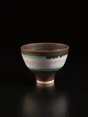 Footed bowl by Lucie Rie, circa 1978, Porcelain, pink, turquoise, and golden manganese bands, sold Dec 2017