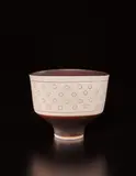 Oval bowl by Lucie Rie, circa 1970, Porcelain, manganese glaze, with circular impressed designs inlaid with glaze, sold Dec 2017
