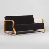 Model '544' sofa by Alvar Aalto, the bent birch plywood sides with black fabric upholstery, sold Apr 2026