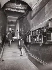 Robert Doisneau, Entrance to the Guignol puppet theatre, Lyon 1957, 1957, Vintage silver print on single-weight glossy paper, in very good condition. Photographer's name stamp in blue ink and "Rapho" agency stamp in red ink, several handwritten numbers, cropping marks and a