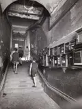 Robert Doisneau, Entrance to the Guignol puppet theatre, Lyon 1957, 1957, Vintage silver print on single-weight glossy paper, in very good condition. Photographer's name stamp in blue ink and "Rapho" agency stamp in red ink, several handwritten numbers, cropping marks and a