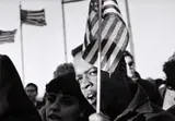 Hiroji Kubota, Protesters with US flags, Washington DC 1965, 1965, Vintage silver print on double-weight semi-matte paper, in excellent condition. Signed in black ink, Magnum distribution stamp, date stamp "1965", handwritten negative no. "65-3-1/28" and credited "H.