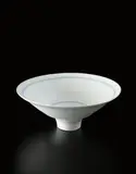Flaring footed bowl by Lucie Rie, circa 1978, Porcelain, matte white glaze over concentric inlaid blue lines repeated inside and out, sold Dec 2016