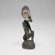 East Sepik, Seated Figure, carved and painted wood, cowrie shells