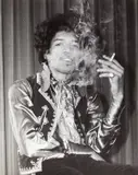 George Tremlett, Jimi Hendrix smoking, 1967, Vintage silver print on single-weight ferrotyped paper, in very good condition. Photographer's stamp, "Redaktion Archiv" stamp and annotated "Jimi Henrix" in blue felt-tip pen on the reverse. George T