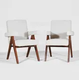 Pair of model 'PJ010808' chairs by Pierre Jeanneret, c.1954, each of teak with bouclé upholstery, sold Oct 2025