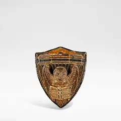 Robert Wallace Martin, for Martin Brothers, 1878, Glazed earthenware, modelled as an owl holding a book, the backing plate modelled as a shield