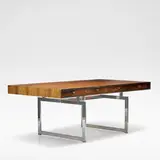 Bodil Kjaer, for E. Pedersen & Son, Rosewood and chromed metal, the rectangular top with four recessed frieze drawers, raised on rectangular chromed metal supports