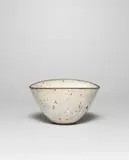 Squeezed bowl by Lucie Rie, circa 1964, Stoneware mixed with manganese minerals beneath a shiny white glaze creating an integral speckle, sold Apr 2024