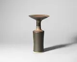 Cylindrical vase with flaring lip by Lucie Rie, circa 1985, Porcelain, bronze manganese and dry terracotta glazes, sold Apr 2024