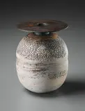 Ovoid pot with disc by Hans Coper, circa 1965, Stoneware, layered white porcelain slips and engobes over a body with textured and incised linear designs, the neck and , sold Dec 2015