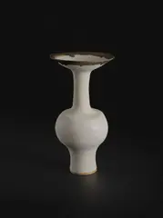 Bottle vase with flaring lip by Lucie Rie, circa 1985, Stoneware, matt white glaze with golden manganese lip, sold Dec 2023