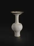Bottle vase with flaring lip by Lucie Rie, circa 1985, Stoneware, matt white glaze with golden manganese lip, sold Dec 2023