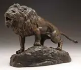 Thomas François Cartier, Lion, Fine bronze of a standing lion with open mouth and outstretched tail. Standing on an uneven, naturalistic base