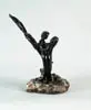 Lebuse, The Embrace with Dolphins, Carved black coral sculpture shows male and female mermaids embrace next to carved pillar of dolphins