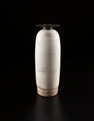 Hans Coper, Large bottle vase with disc top, circa 1972, Stoneware, white layered porcelain slips over a body with textured designs. The lip and neck with manganese glaze