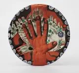 Pablo Picasso, Mains au Poisson (Hands with Fish), 1953, Red earthenware round dish painted in russset, green, blue, ivory and black with deep engraving and partial brushed glaze,