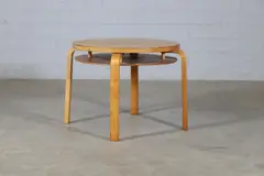 'Model 70' coffee table by Alvar Aalto, 1933, the circular birch top over an undertier shelf and raised on four birch bentwood supports, sold Jan 2025