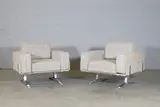 William Plunkett, Pair of club armchairs, c.1970, each with cream upholstery and raised on aluminium supports