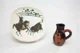 Picador; and Picador and Bull by Pablo Picasso, 1952; and 1953, Two ceramics, including one partially glazed terracotta pitcher, and one glazed white earthenware plate painted in black, sold Oct 2013